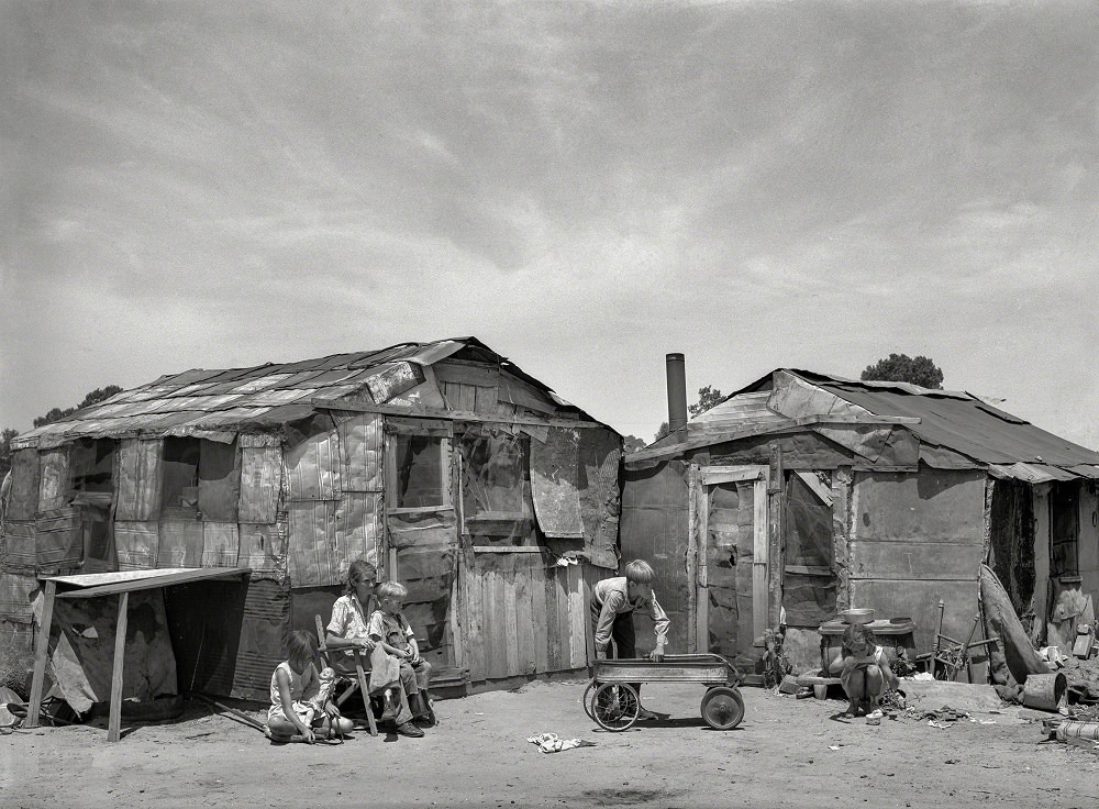Family in front of shack home, May Avenue camp, Oklahoma City, July 1939