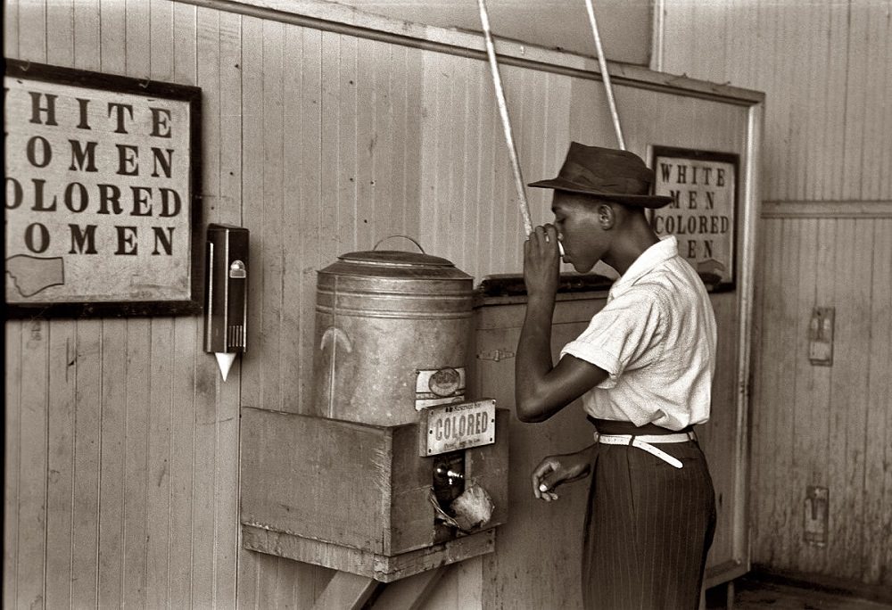 Negro drinking at 'colored' water cooler in Oklahoma City streetcar terminal, July 1939