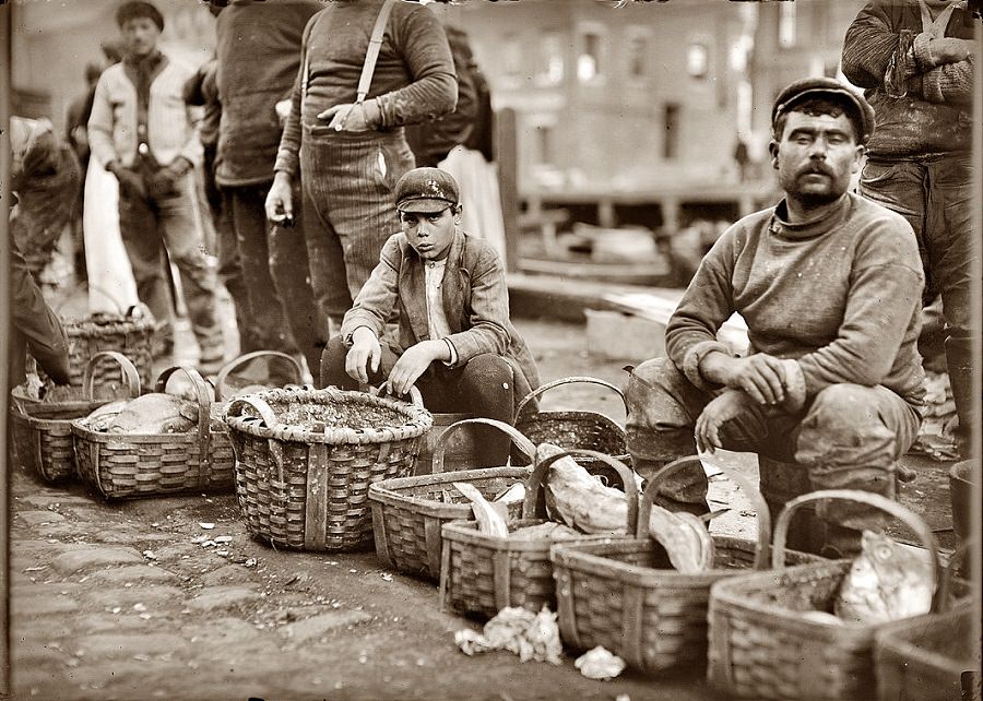 Boy selling fish from a basket in Boston street market, October 1909