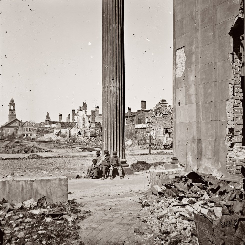 View of ruined buildings through porch of the Circular Church at 150 Meeting Street, Charleston, April 1865