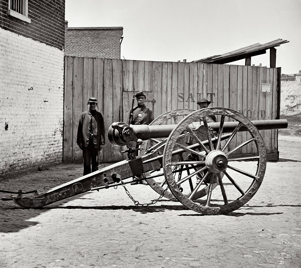 Federal soldier guarding Whitworth gun on wharf awaiting shipment, Richmond, Virginia, April 1865