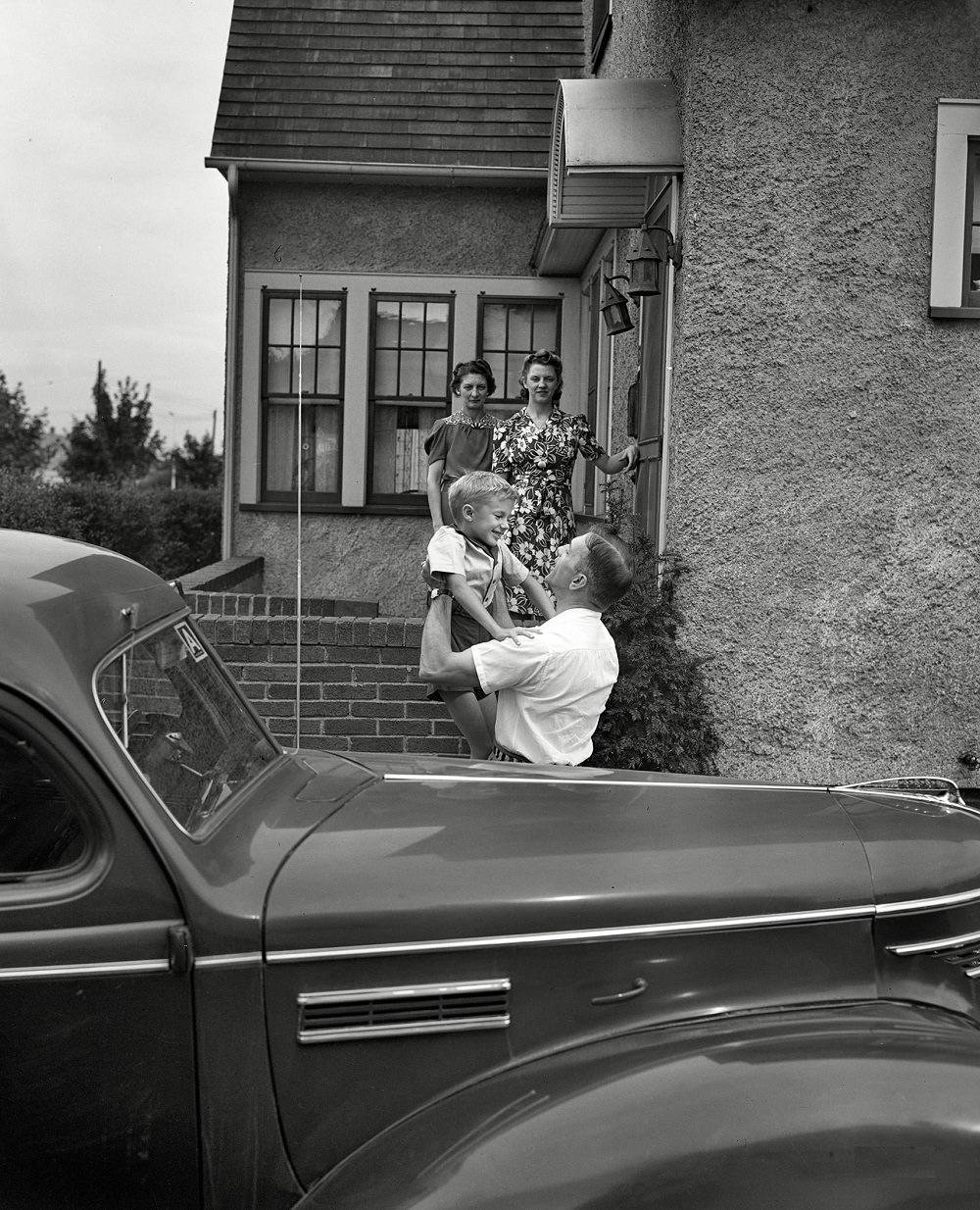 Babcock, Shirley and Earl greeting Mr. Babcock in front of the house, New York, September 1942