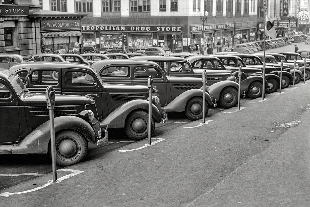 Cars parked diagonally along a row of parking meters, Omaha, Nebraska, November 1938