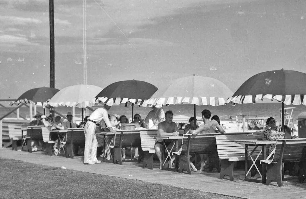 Beachgoers sit under umbrellas at the Pensacola Beach Casino, 1930s
