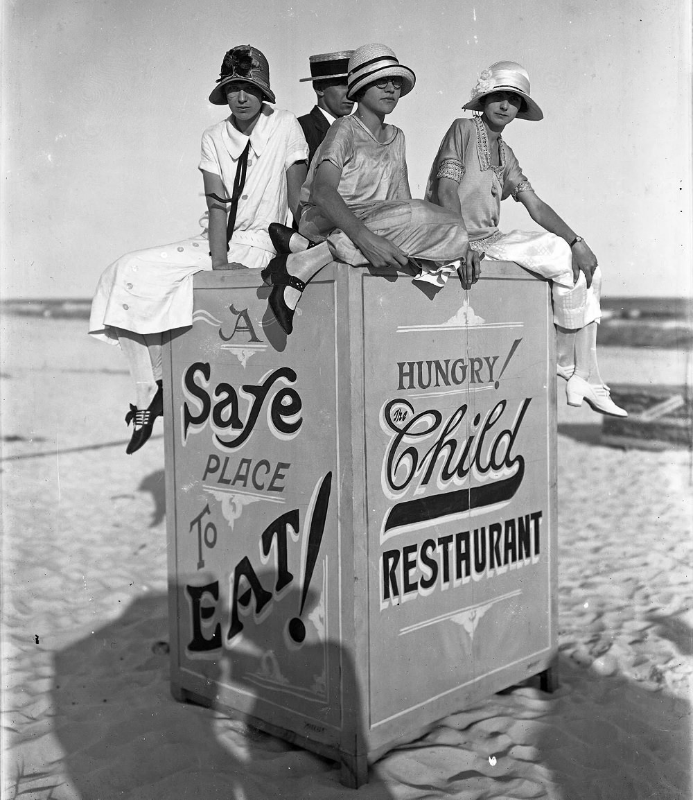 Young ladies at Pensacola Beach sitting atop a sign for the Child Restaurant, circa 1935