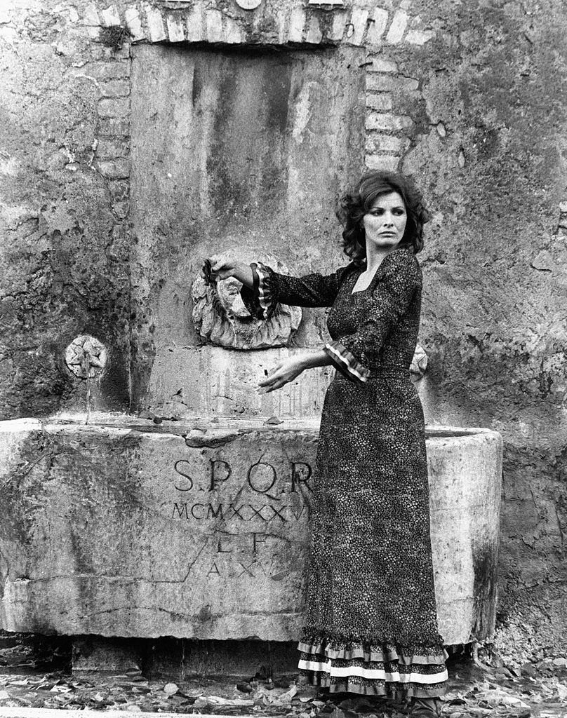 Scilla Gabel beside a 1936 fountain with a gargoyle, Rome, 1970s
