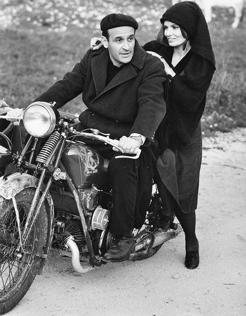 Scilla Gabel with the Italian actor Pier Paolo Capponi on a Guzzi motorcycle on the set of the TV serial 'Vino e Pane', Avezzano, 1972