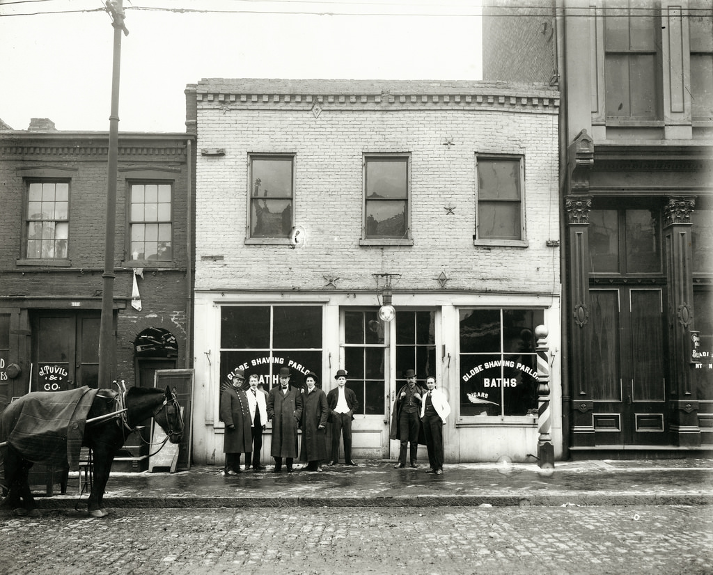 Group of men standing in front of the Globe Shaving Parlor at 1015 Carr, 1910