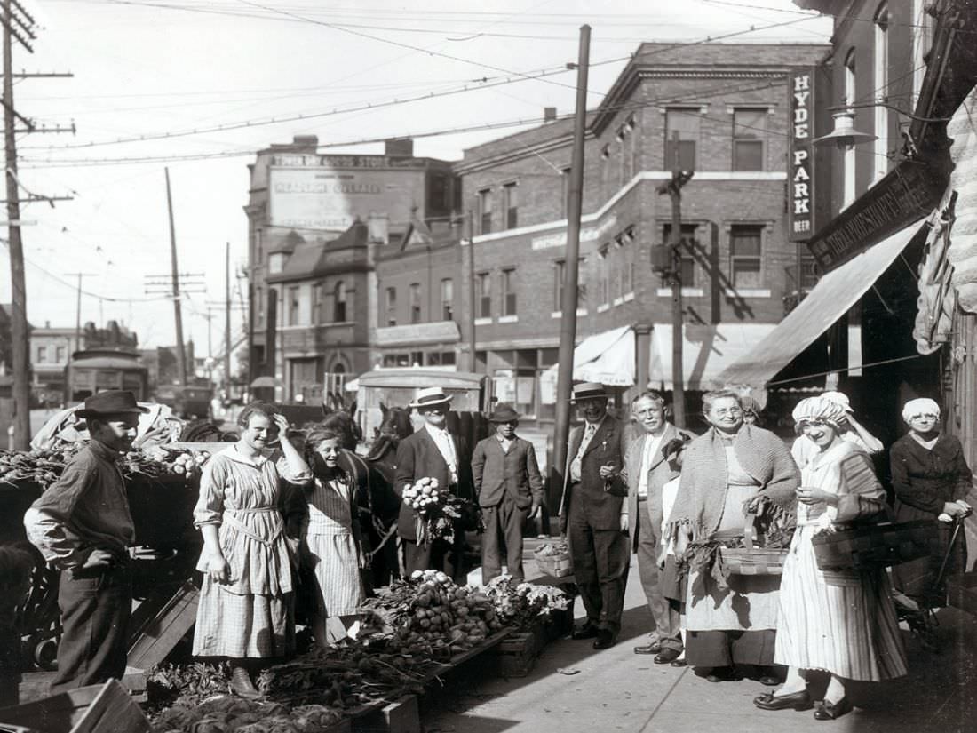 Shoppers gathered by sidewalk produce outside the Theodore Prieshoff Grocery, 1929