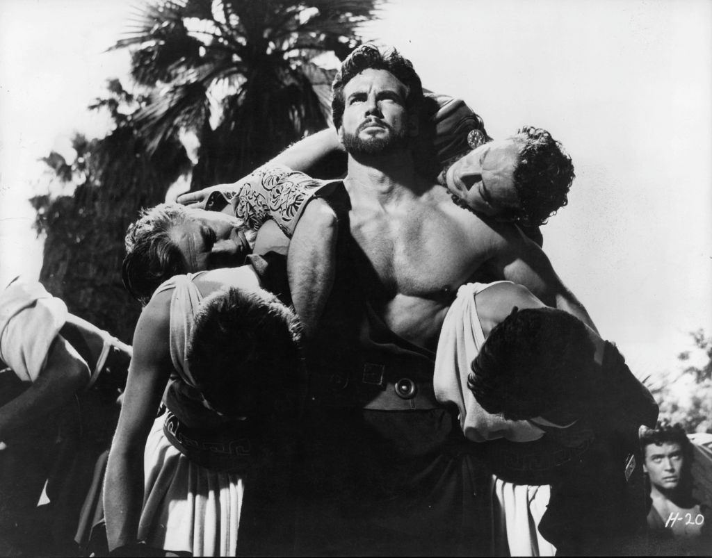 Steve Reeves carrying unidentified men in a scene from the film 'Hercules Unchained', 1959