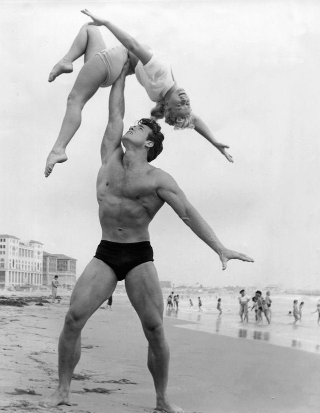 Steve Reeves with an unknown woman on the beach, 1950s
