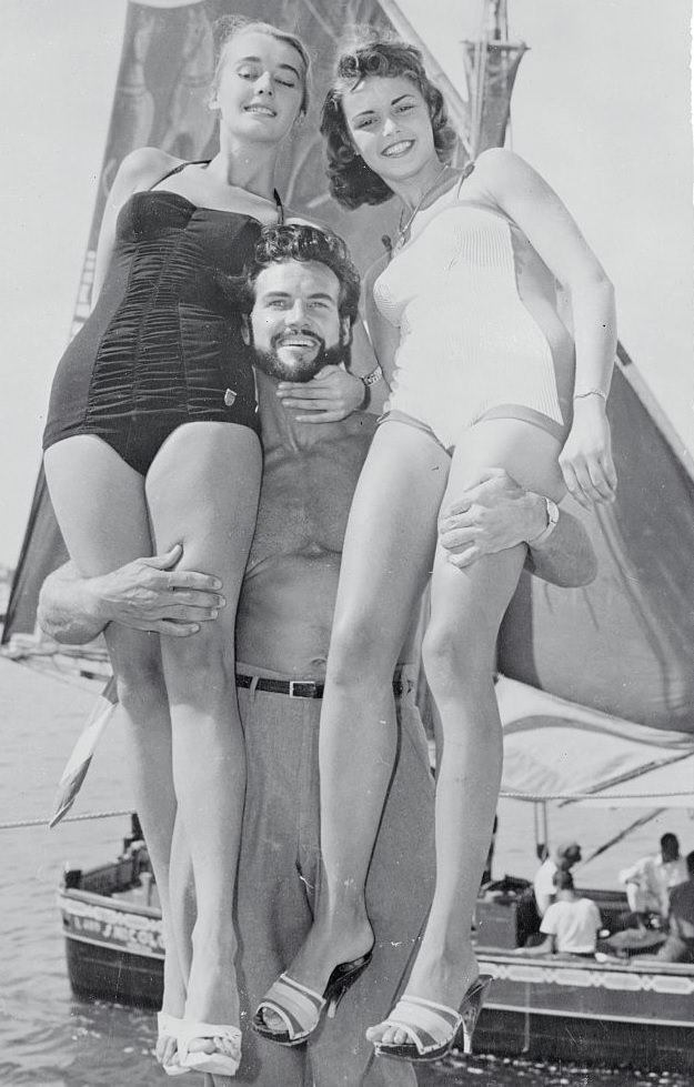 Steve Reeves Posing with Beauty Contestant Winners on Shore, 1950s