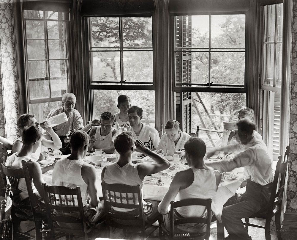 Syracuse freshmen on the rowing team sit around the dinner table on June 19, 1908