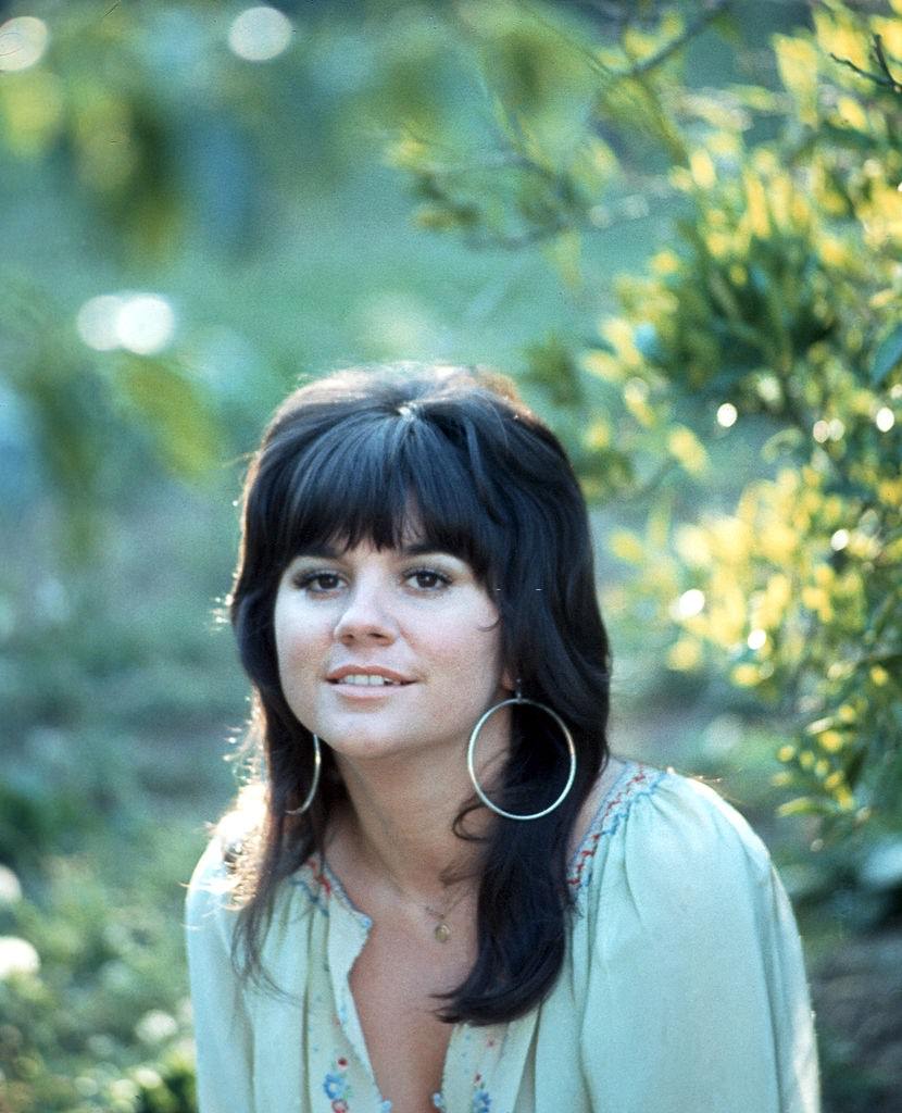 Linda Ronstadt in a garden during a photoshoot, 1970