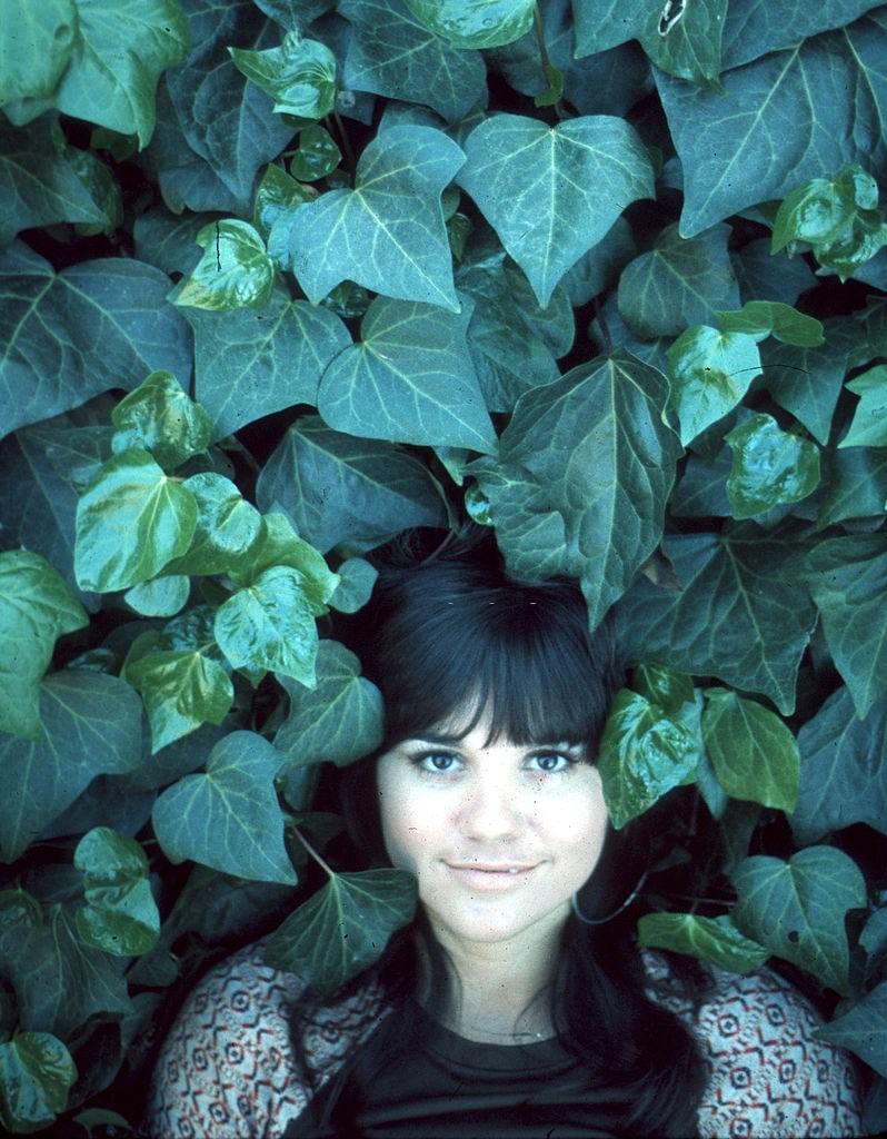 Linda Ronstadt photographed in a garden, 1970