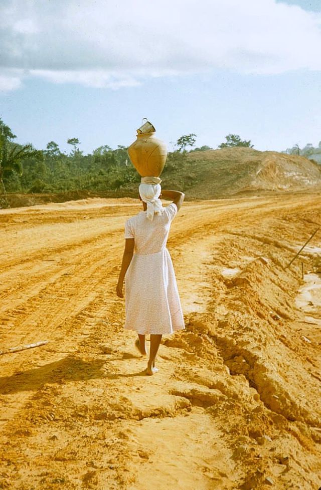 Woman walking while carrying a large jar on her head, Brazil, 1958
