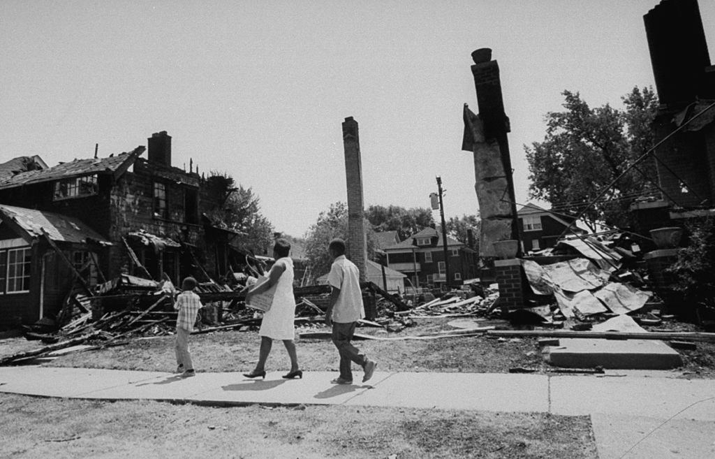 Detroiti verseny zavargások következményeként, a család sétálva a kibelezett épületek törmelékéből, Detroit, 1967