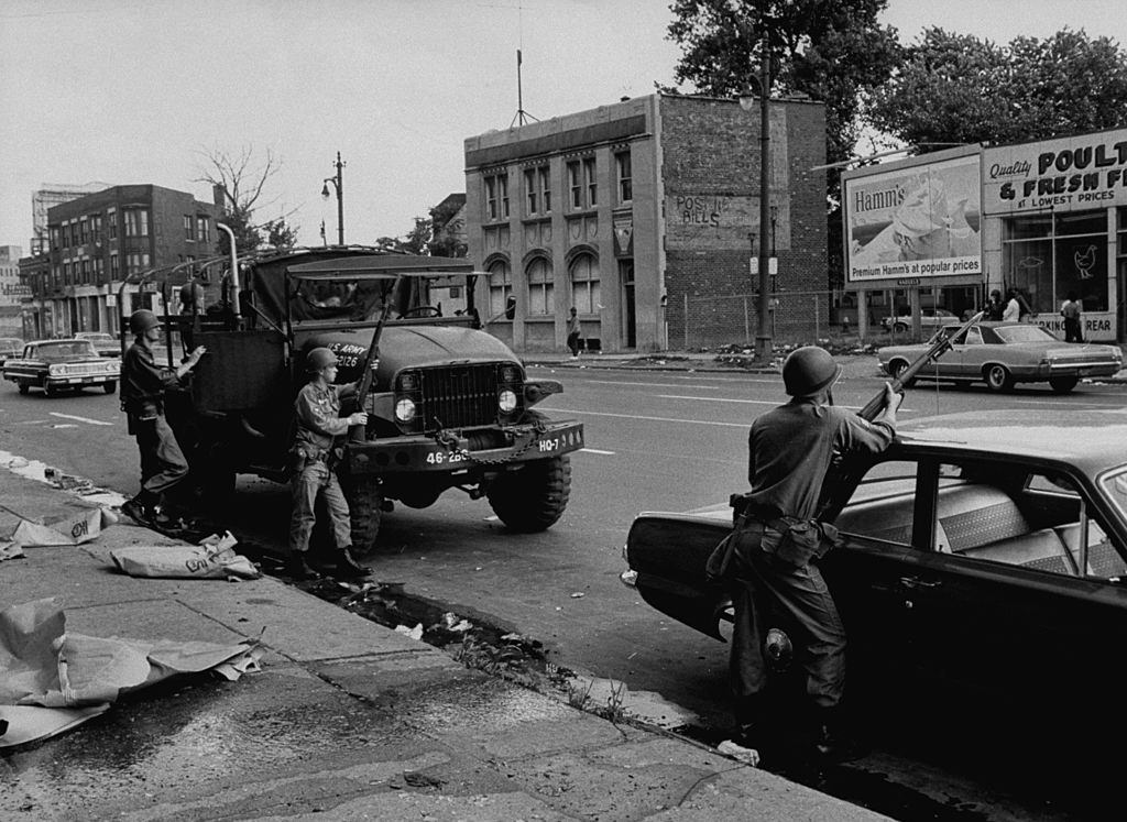 During race riots in Detroit, National Guard patroling devastated neighborhood, 1967