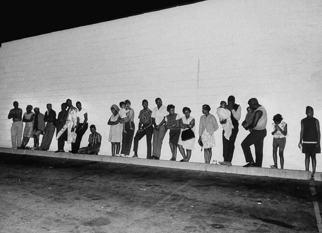 Police evacuate apartment building in search of sniper suspects, during riots, 1967