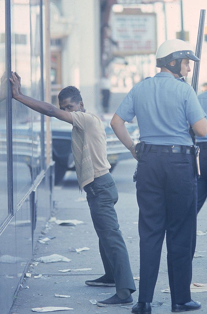 Policeman arresting an African American after race riots, 1967