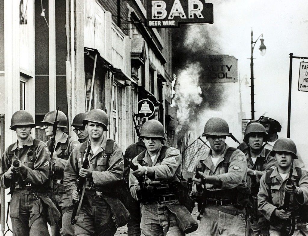 Tough looking Michigan National Guardsmen with fixed bayonets on the streets during race riots in the city, 1967