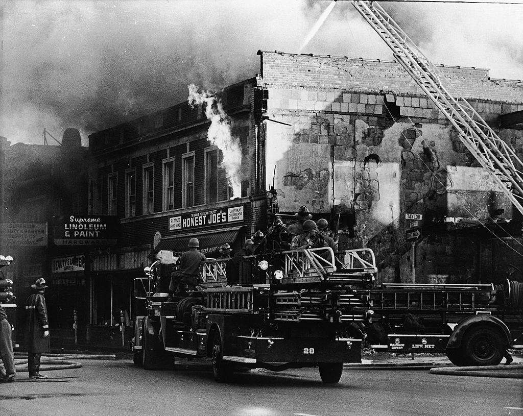 Federal troops ride on a fire engine to protect the firefighters from snipers during the riots in Detroit, 1967