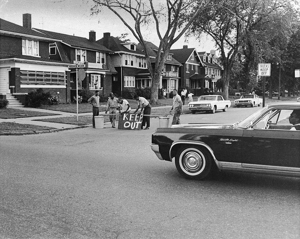 A group of men construct a barricade out of wood and garbage cans to keep their street safe during the riots, Detroit, Michigan, July 27, 1967