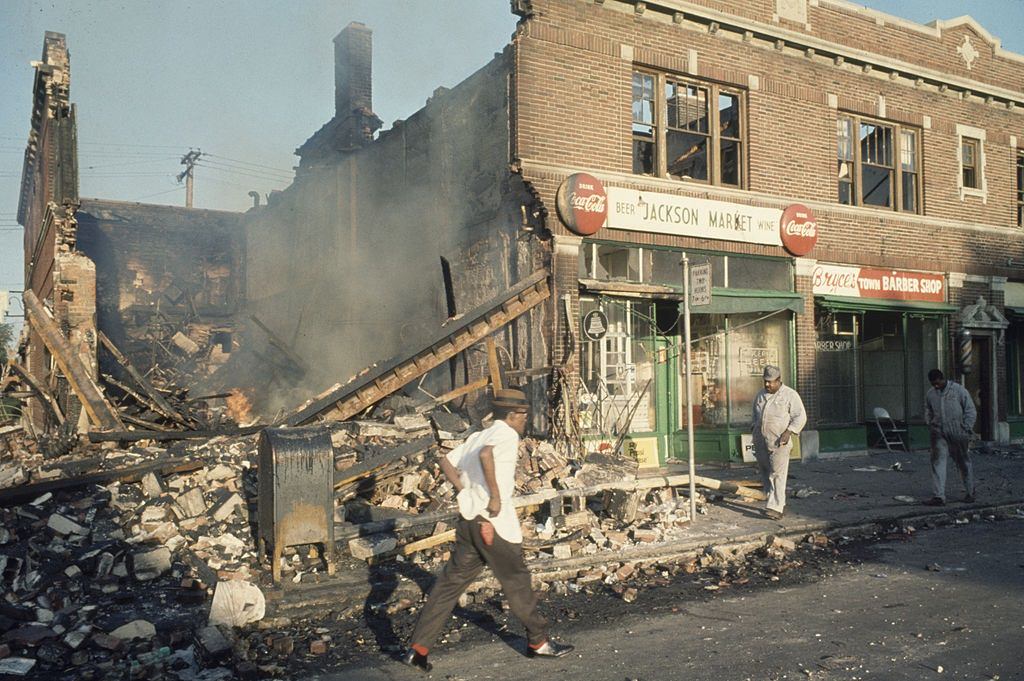 Egy detroiti rendőr egy élelmiszerbolt végsapkán áll, hogy megvédje a további fosztogatást a 1967-es Detroiti zavargások során