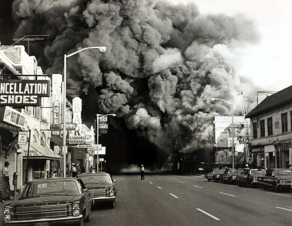 Egy hatalmas mennyiségű füst önt egy égő épületből a városban zajló verseny zavargása során, 1967