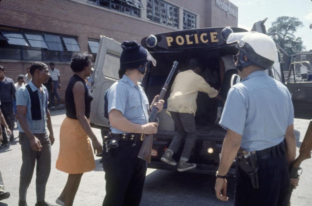A rendõri tisztviselõk gyanúsítottak egy rendõrségi tehergépkocsiba a folyamatos zavargások nyomán, Detroit, Michigan, 1967