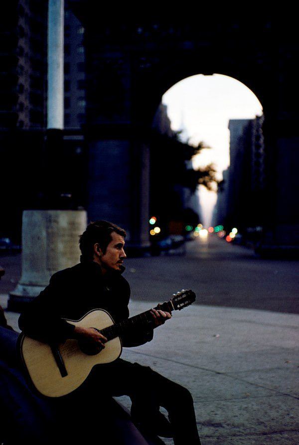 A man plays guitar at dusk in Washington Square Park in 1959.