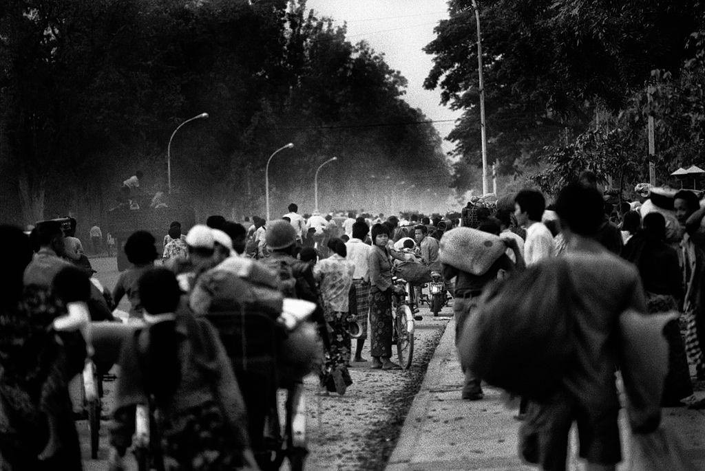 Phnom Penh őszi esti este a Khmer Rouge-hez, 1975. április 16-án, mint éjszakai esés, több ezer ember áramlik Phnom Penh központja felé, a Monivong sugárúton.