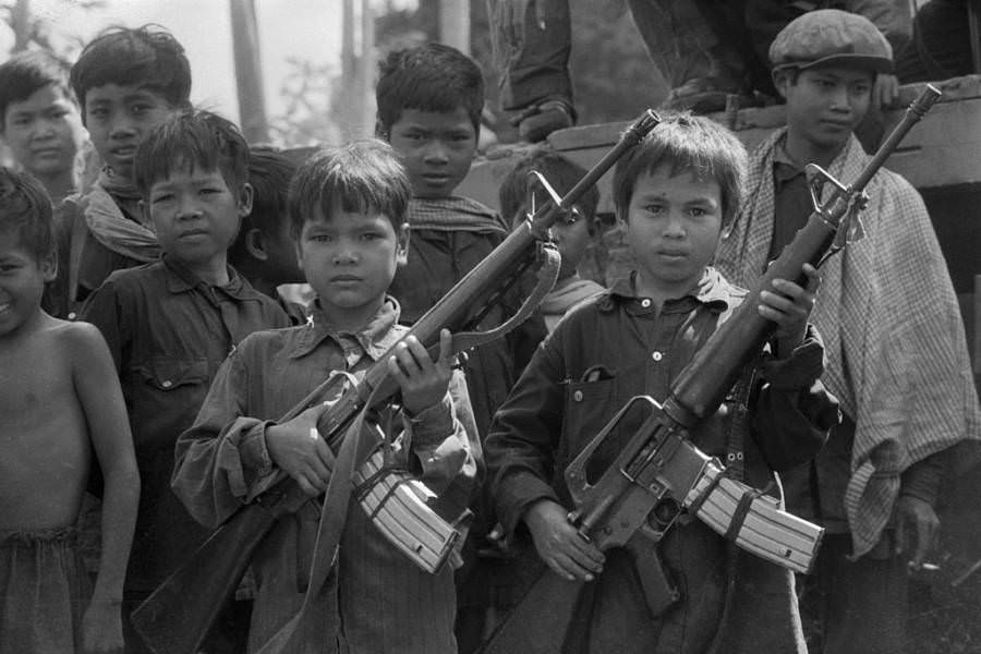 Child soldiers working for the Khmer Rouge show off their machine guns, Galaw, Cambodia. Circa 1979.