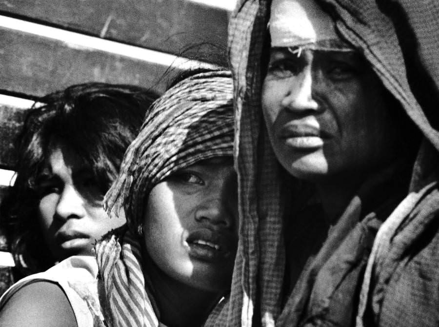 A group of women huddle together, 1975.