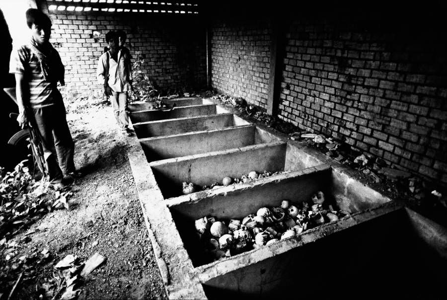 A soldier stands by a mass grave, Oudong, Cambodia. 1981.