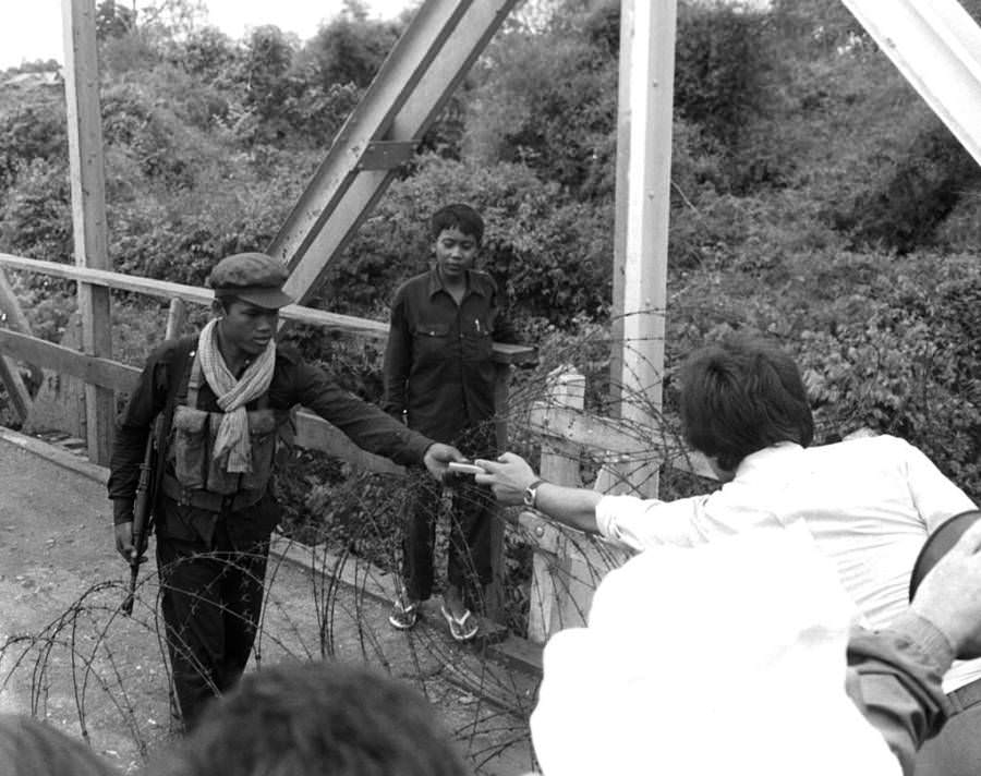 A francia nagykövetség alkalmazottja cigarettát kínál egy khmer rouge-i katona számára, Phnom Penh, 1975.