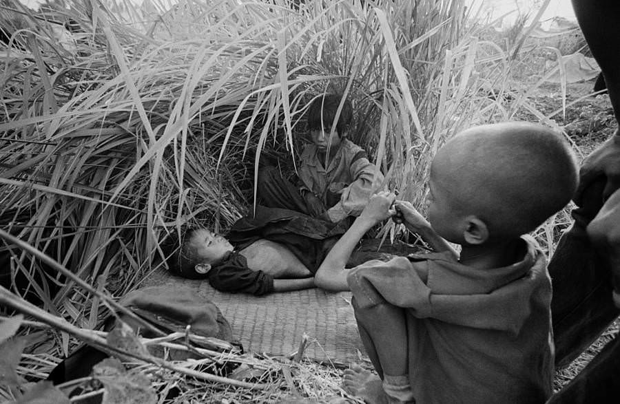 A fiatal menekültek magas fű alatt bujkálnak, elmenekülve a Khmer Rouge gyilkos mezőiről, Aranyaprathet, Thaiföld, 1979.