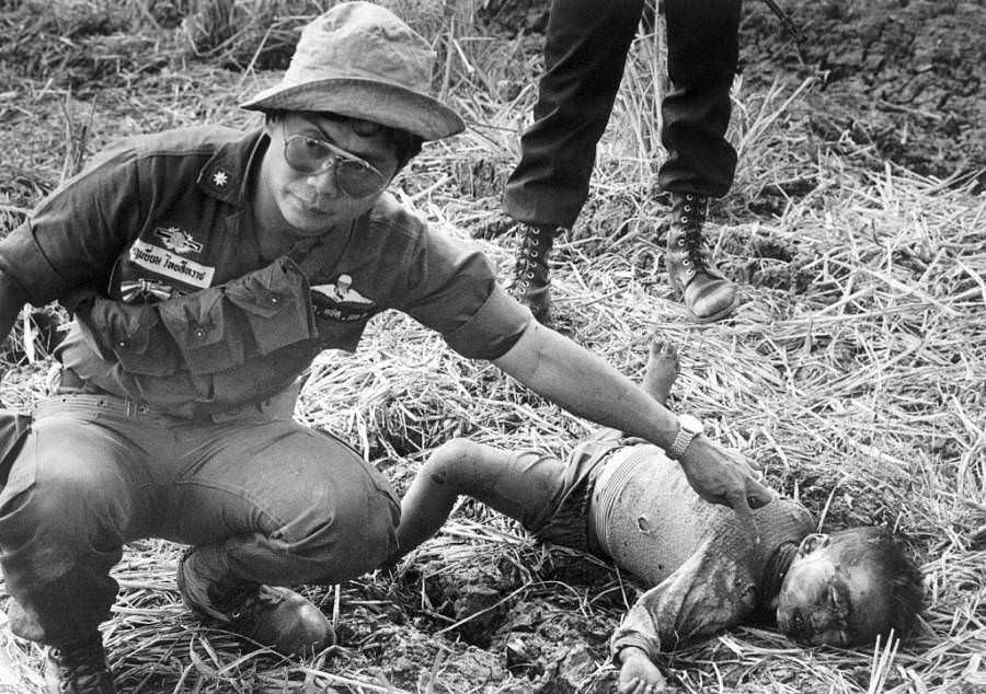 A Thai border patrolman finds a dead child that was killed by Khmer Rouge soldiers, Thailand, 1977