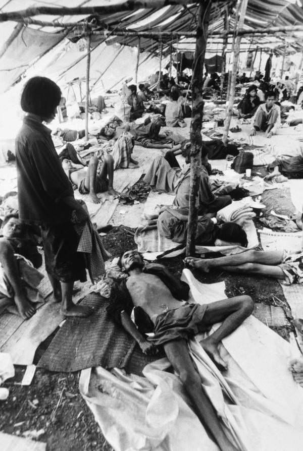 Starving refugees get help from a Thai relief mission, laying in tents near the border, Pailin, Cambodia, 1979