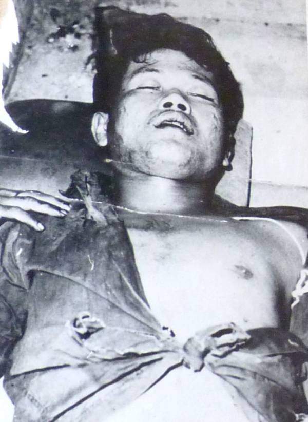 Tuol Sleng hideg talaján fekszik egy halott férfi, nyitott ingével.