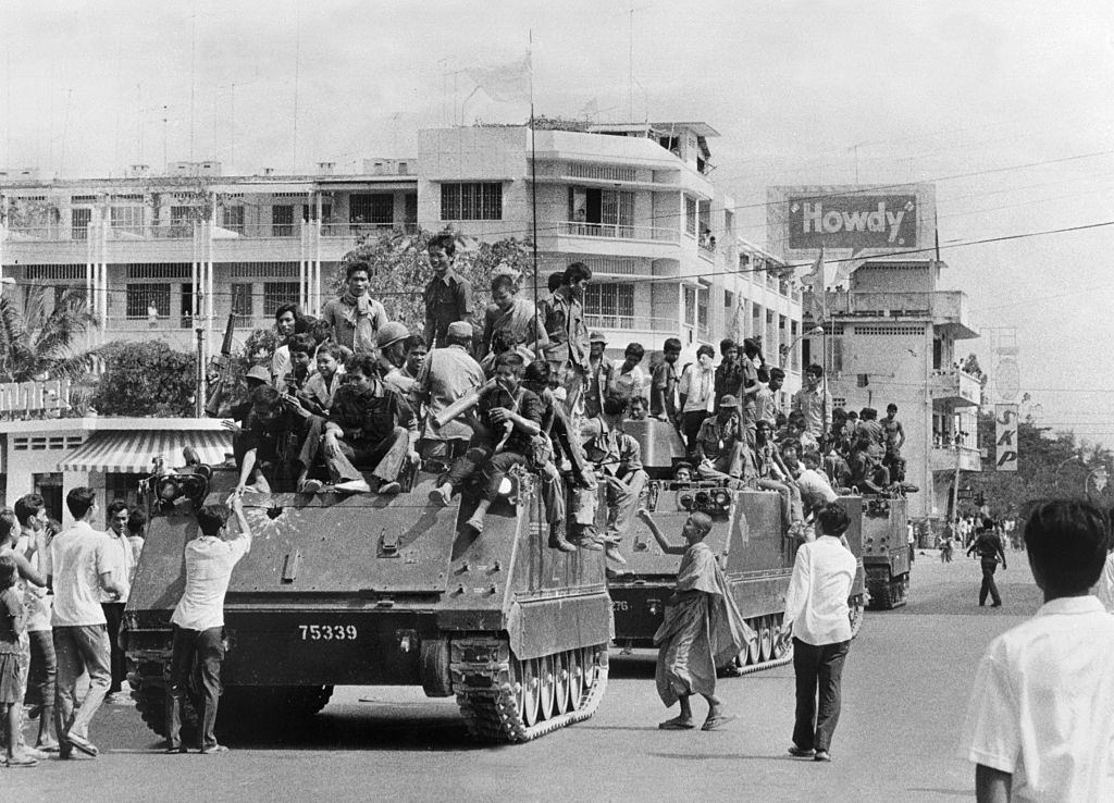 The young Khmer Rouge guerrilla soldiers atop their US-made armored vehicles enter 17 April 1975 Phnom Penh