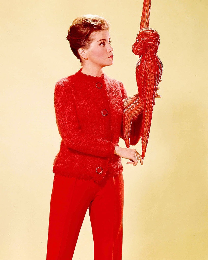 Dolores Hart in red trousers and a knitted red cardigan, 1960