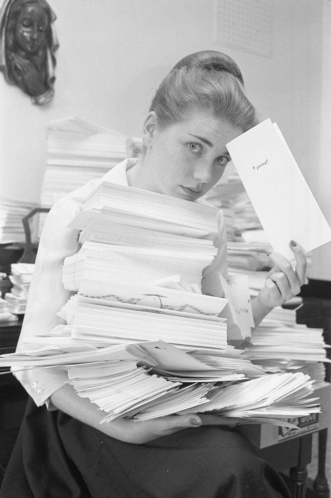 Dolores Hart holds an arm full of greeting cards, 1961