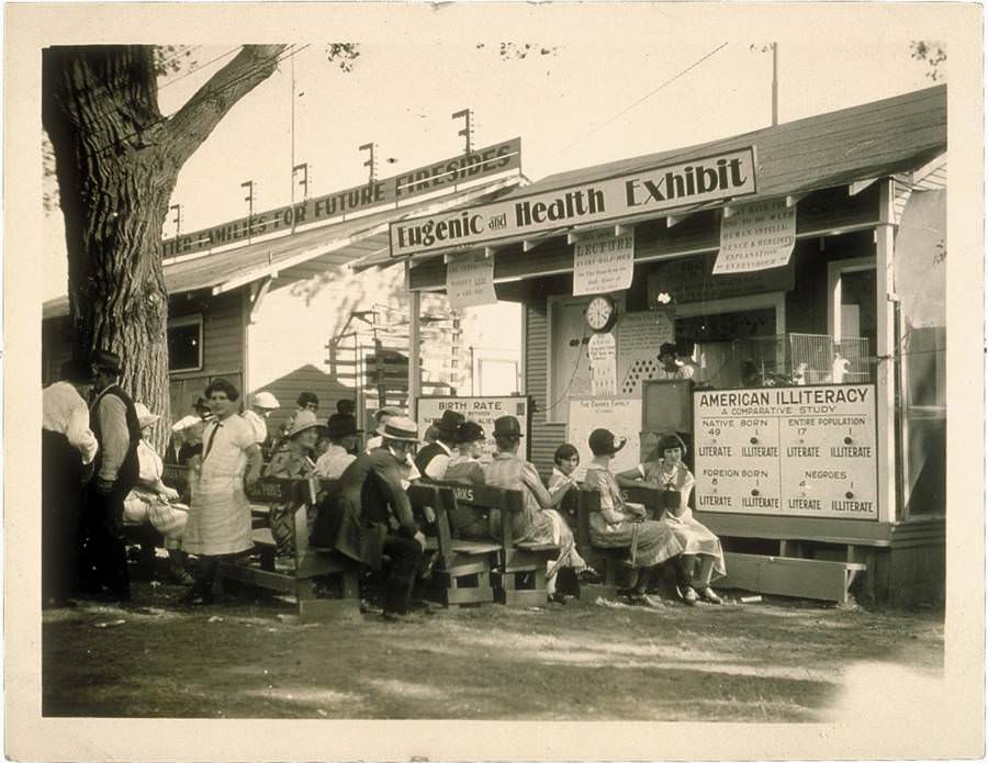 A Eugenics and Health Exhibit teaches the crowd how illiteracy can be controlled through selective breeding in America.