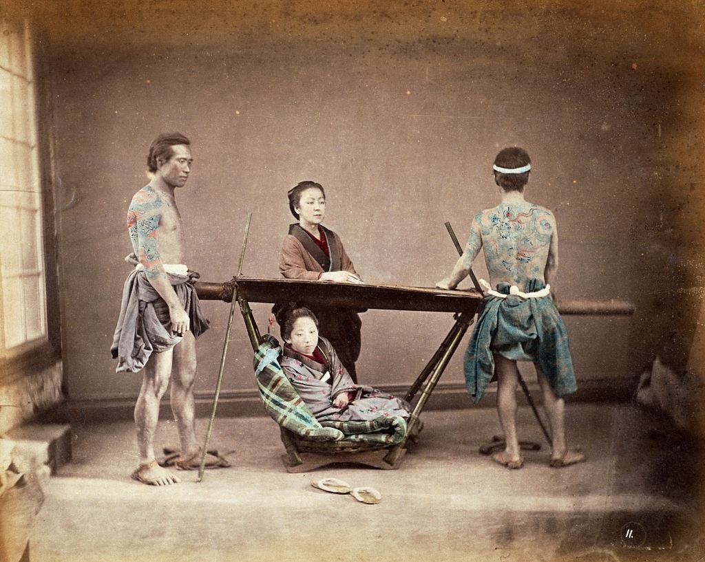 Japanese Sedan Chair, A woman sits in a sedan chair placed to rest by two tattoed bearers, 1865