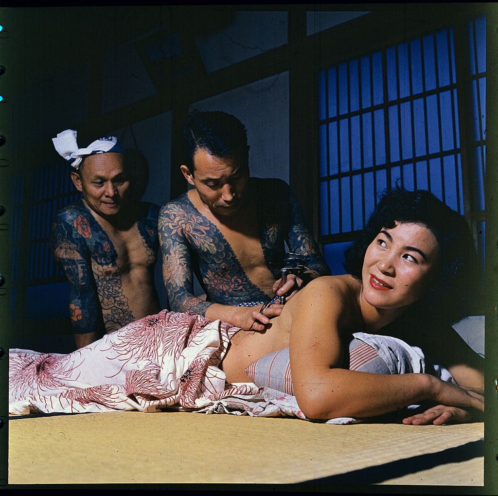 Woman getting tattoo from Tokumitsu Uchida, 1900