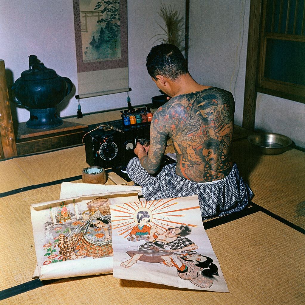 Japanese tattoo artist, Tokumitsu Uchida proudly displaying tattoo markings made by his father, Goro Uchida, who is considered the greatest of them all, 1955