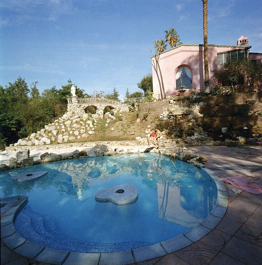 Jayne Mansfield and her familiy stand on the far side of the heart-shaped pool in their backyard, Pink Palace