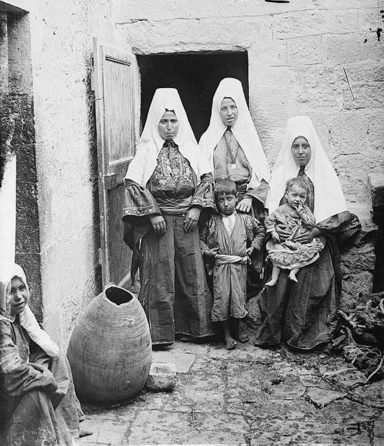 Three women stand by the door with their children.Bethlehem, 1936