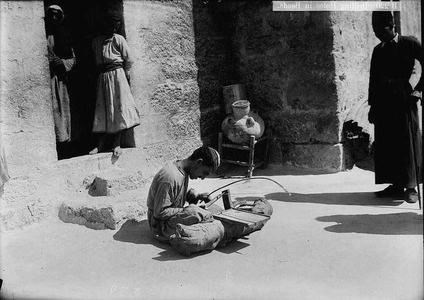 A worker drills holes into beads, Circa 1900-1920